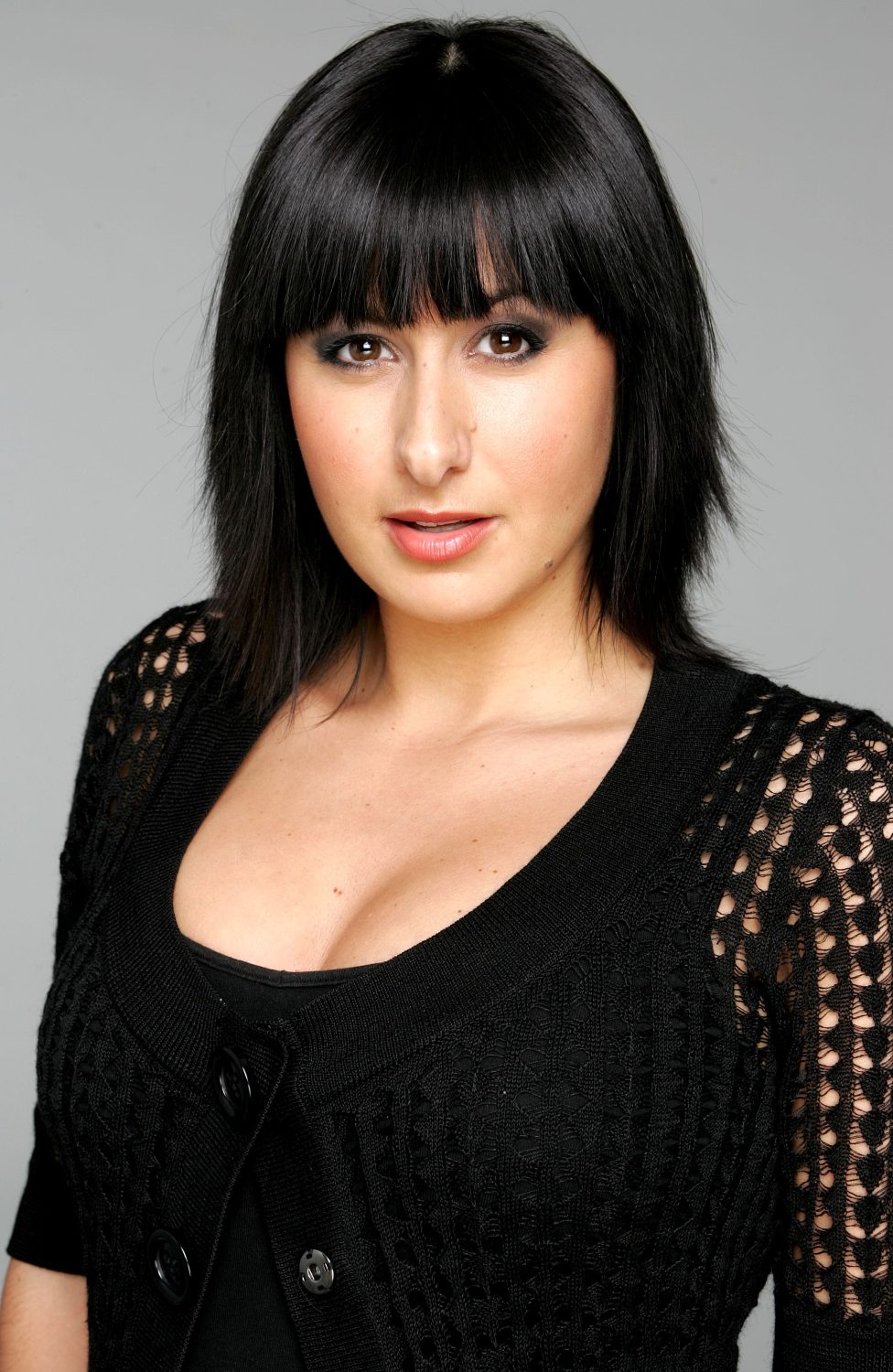 Delilah Dingle press shot, looking sultry dressed in black 