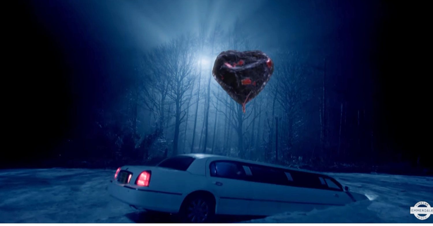 A heart-shaped balloon hovers above a crashed limo on Emmerdale