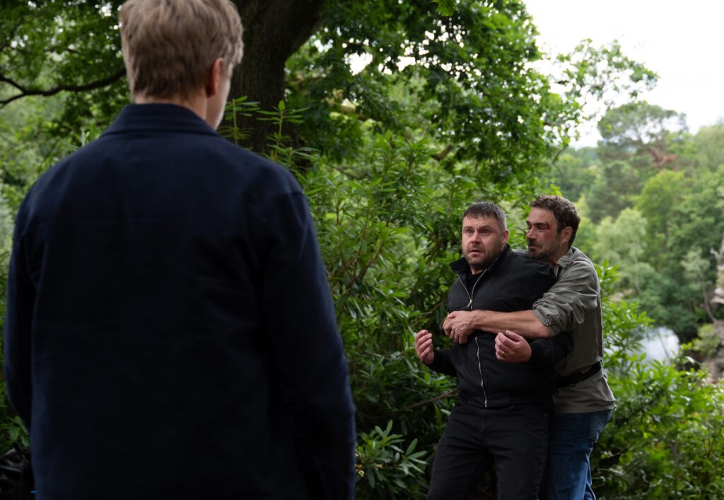 John pulls Aaron over the edge of the gorge in Emmerdale