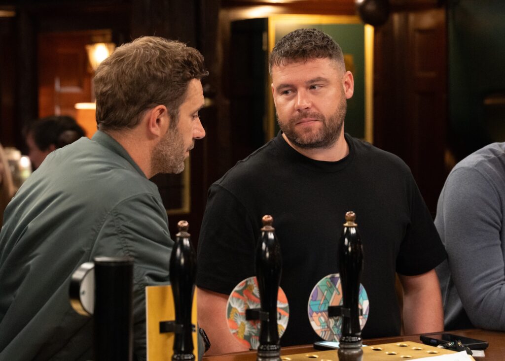 Aaron looks at John in The Woolpack