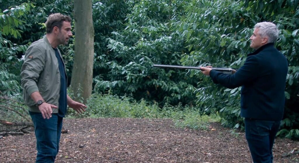 Caleb pointing gun at John in Emmerdale