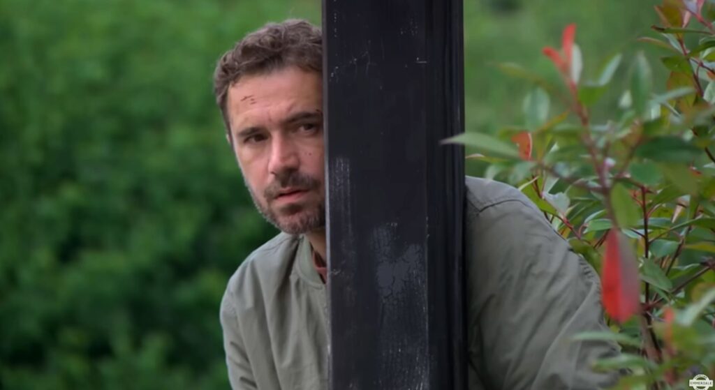 John Sugden hides in Emmerdale (Credit: ITV)