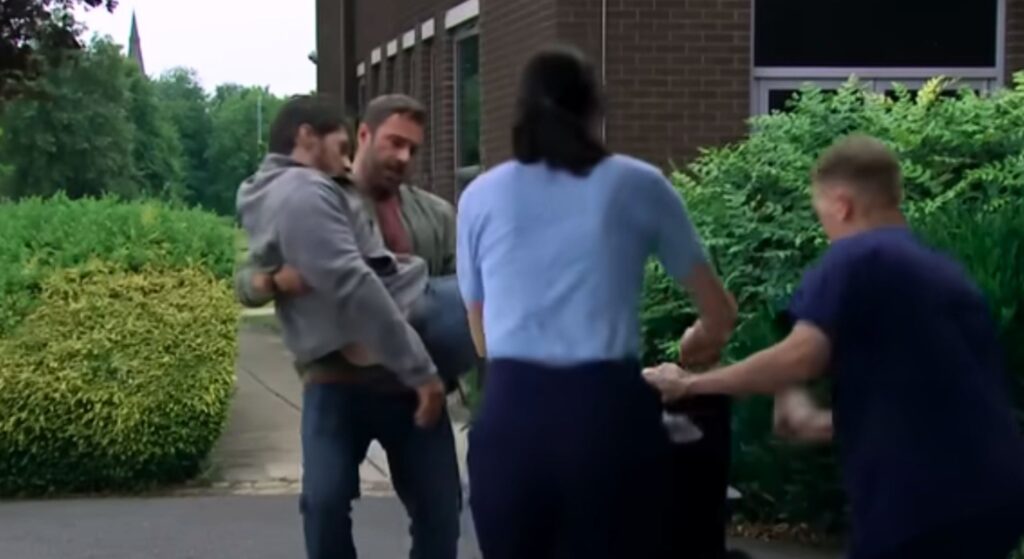 John carries Mackenzie despite his own injuries (Credit: ITV)