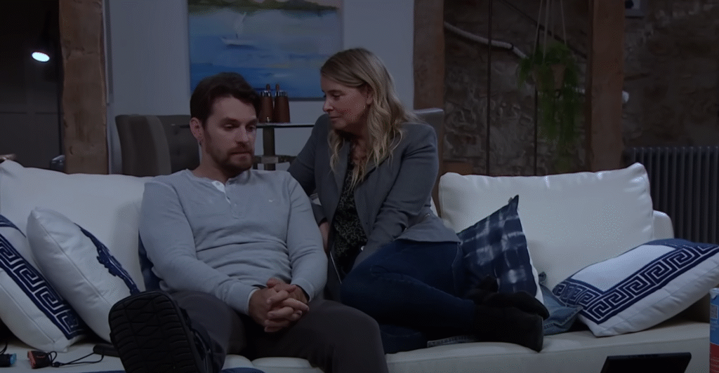 Mack and Charity talking on the sofa