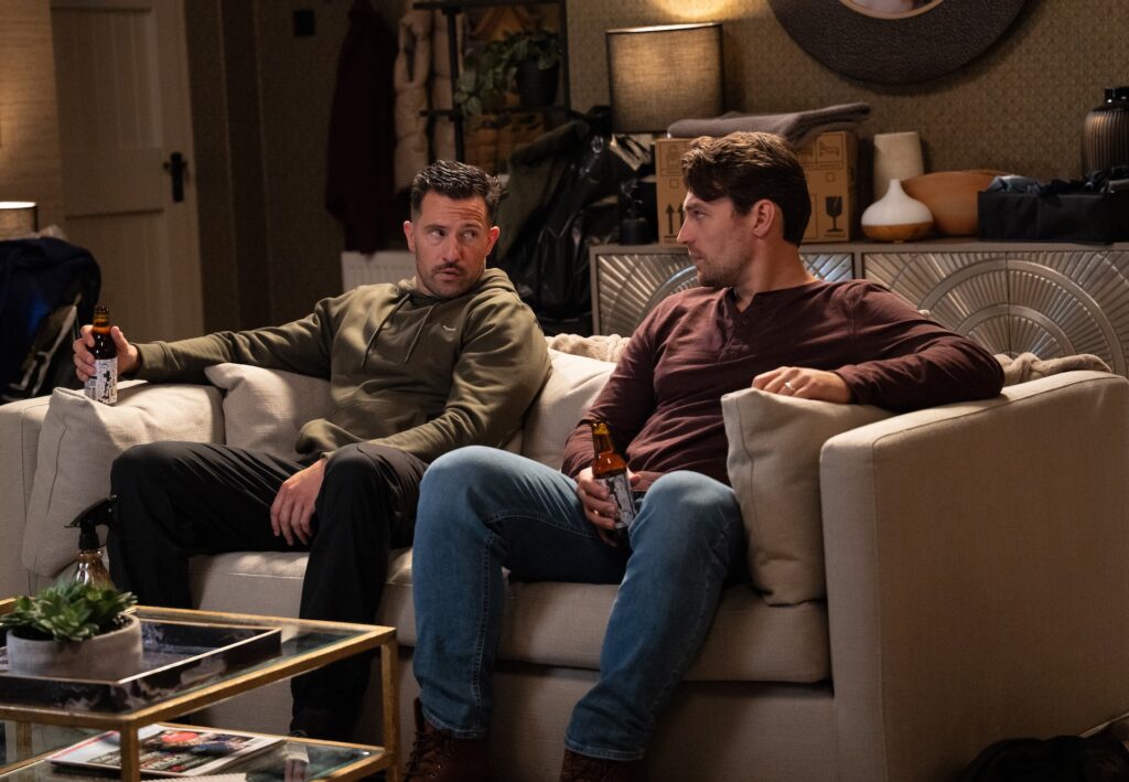 Ross and Mack sit on the sofa together