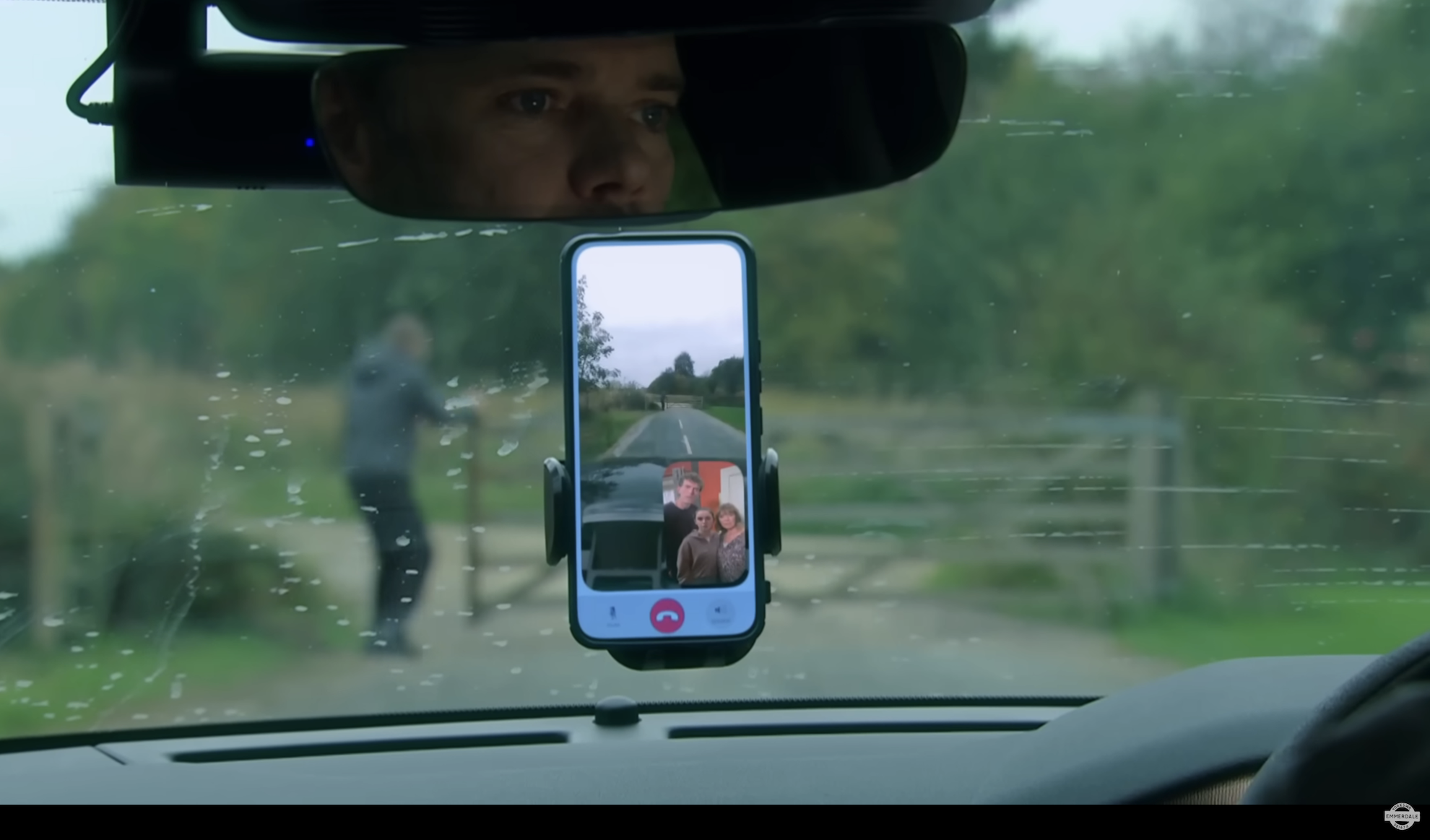 Ray in his car about to run Dylan over with April and her family watching on the phone