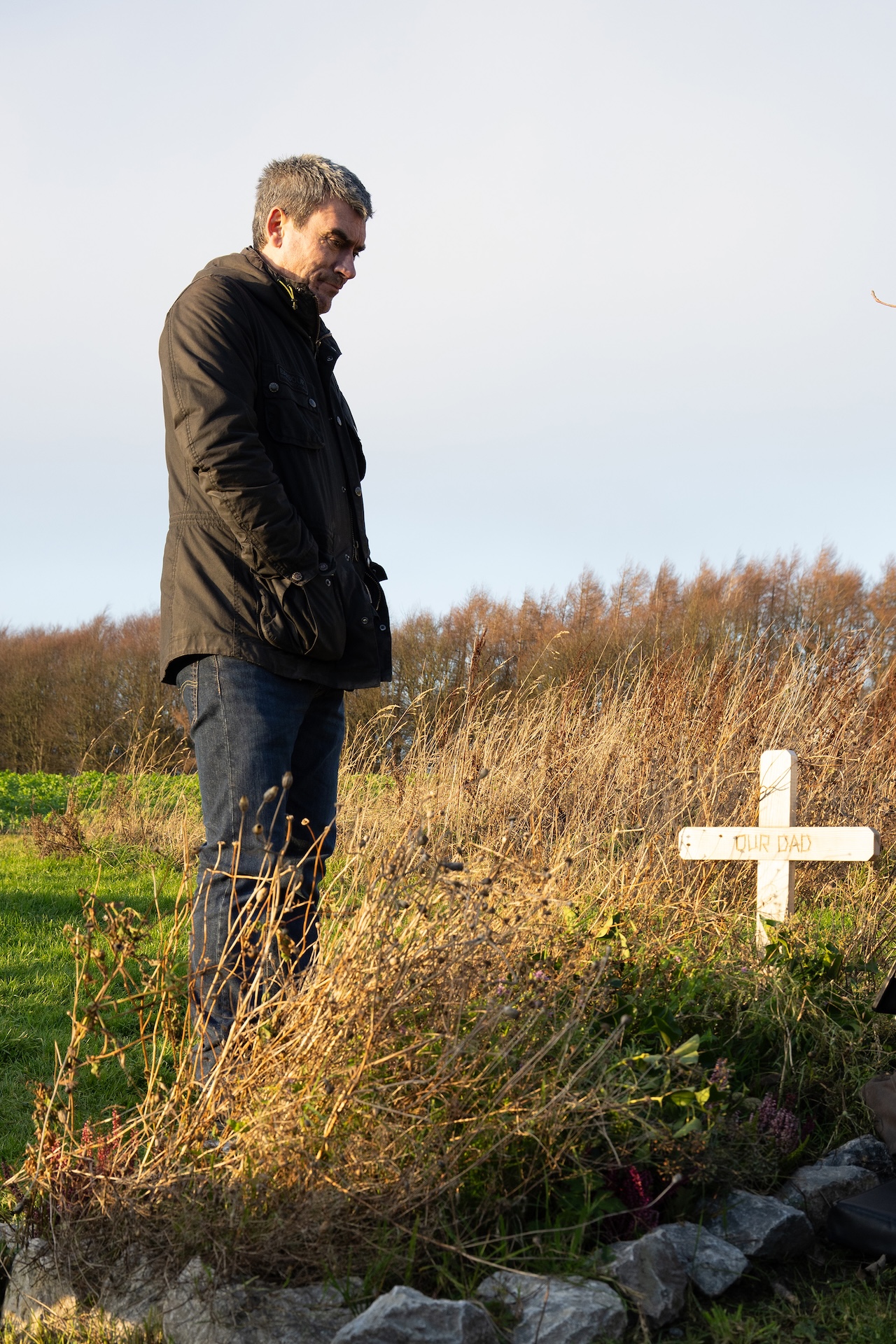 Cain stands at Zak's grave