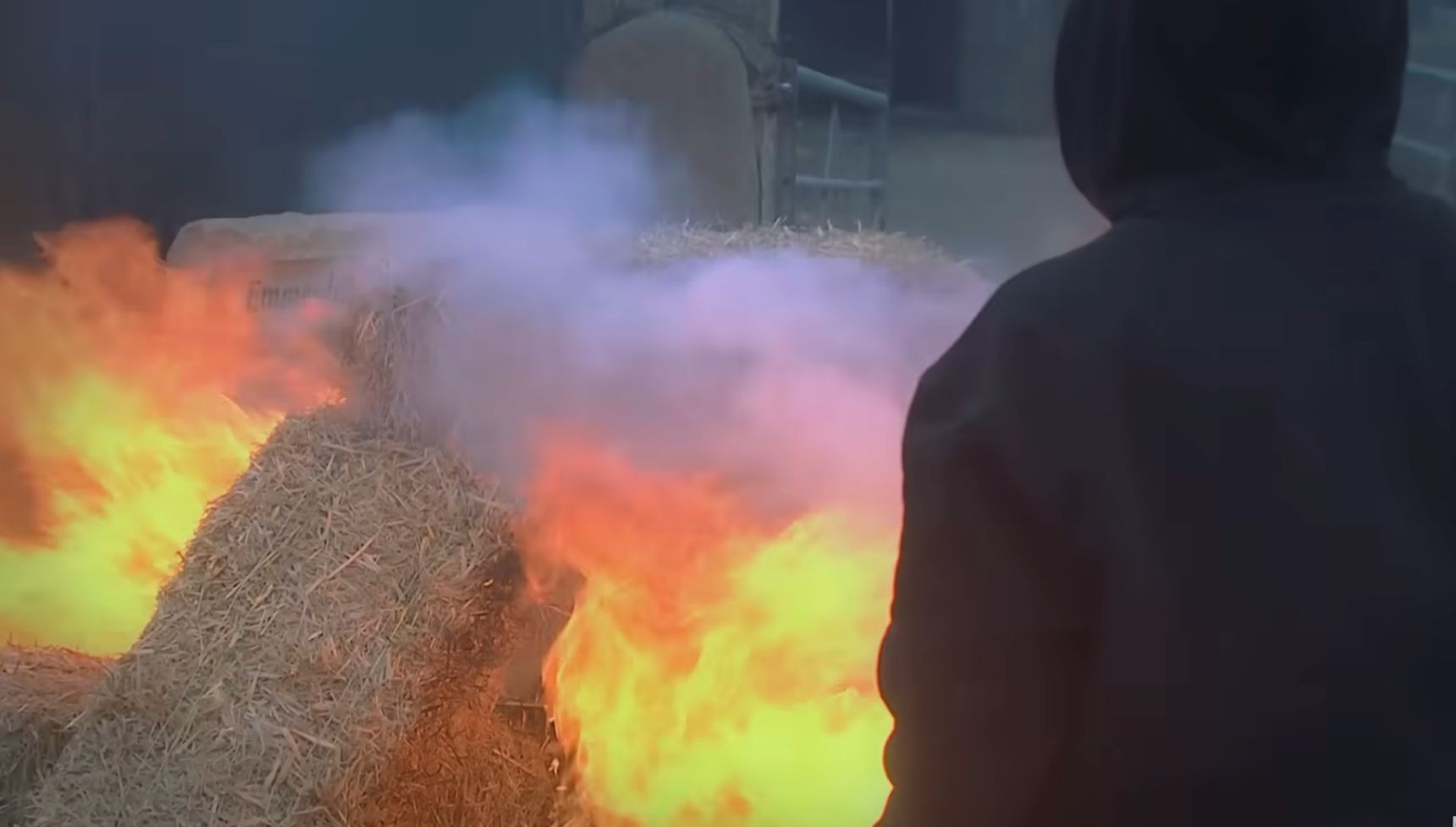 A hooded figure sets the farm on fire in Emmerdale, but who is it? (Credit: ITV)